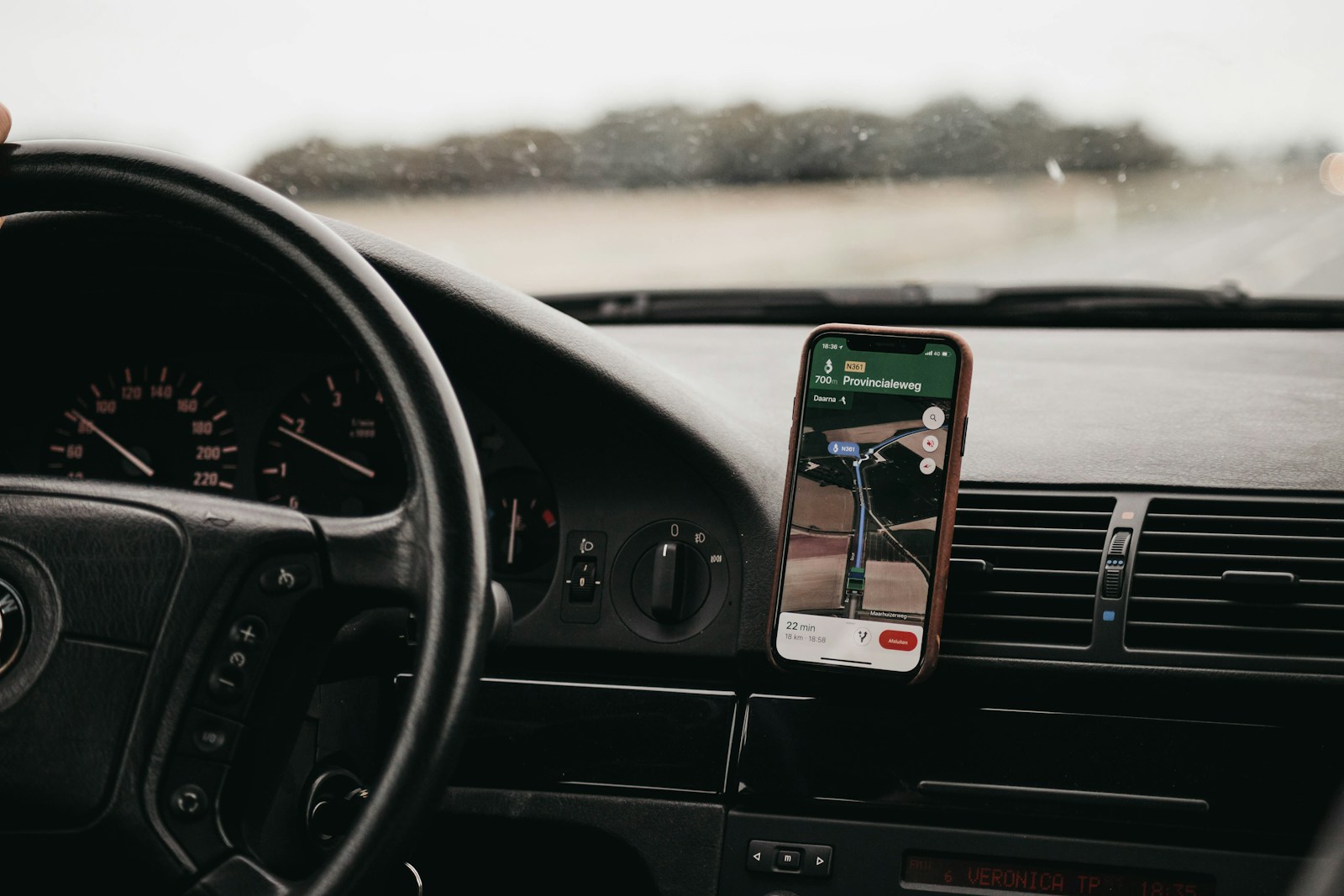 A smartphone running a road-capture app mounted on a vehicle dashboard